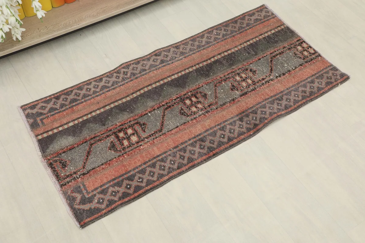 Angled view of the hand-knotted rug showing its striped pattern and colors