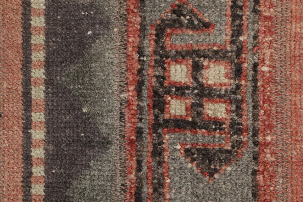 Detailed view of the wool pile and tribal patterns in gray, rust, and brown