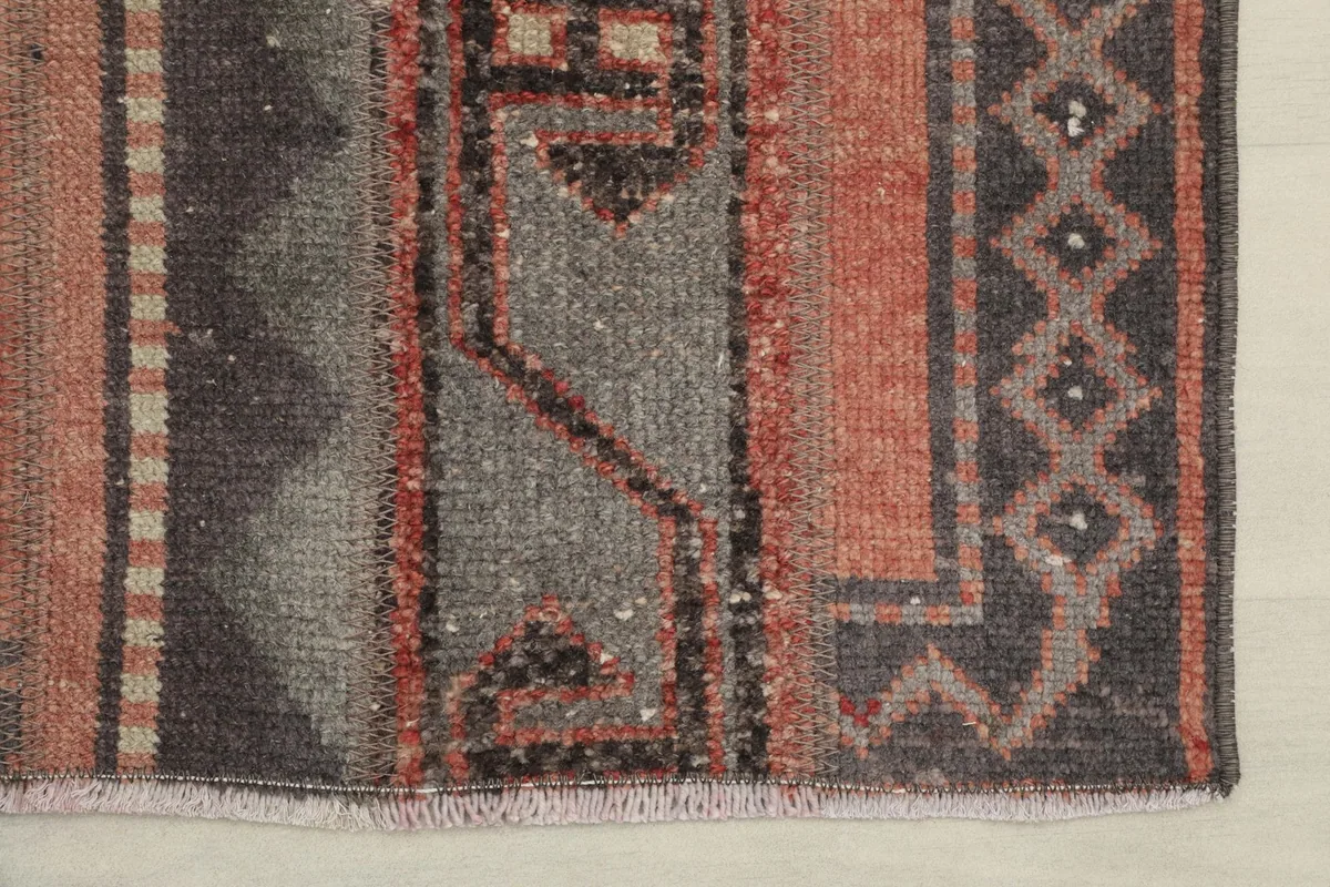 Close-up of the rug's edge, showing the blend of rust, gray, and brown tones