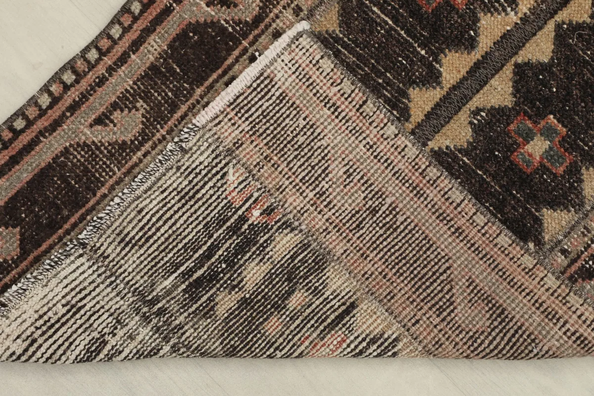 View of the back of the rug, revealing the hand-knotted construction and cotton foundation.