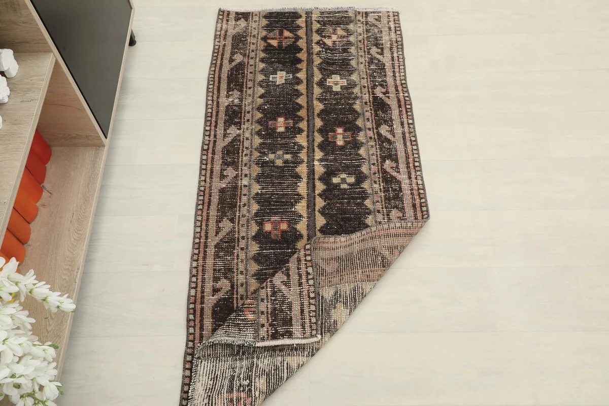 The rug partially folded, illustrating its flexibility and the texture of the vintage wool pile.