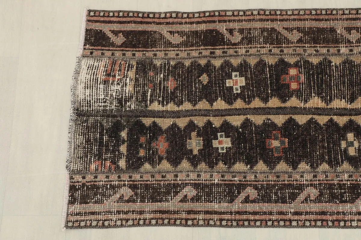 Overhead view of the lower half of the rug, showing the distressed areas and consistent geometric design.