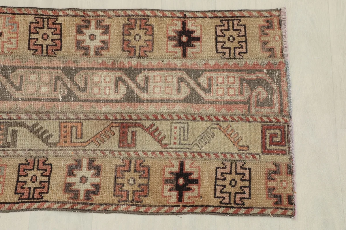 Detail of one end of the rug, showing the edge finish and a section of the patterned field.