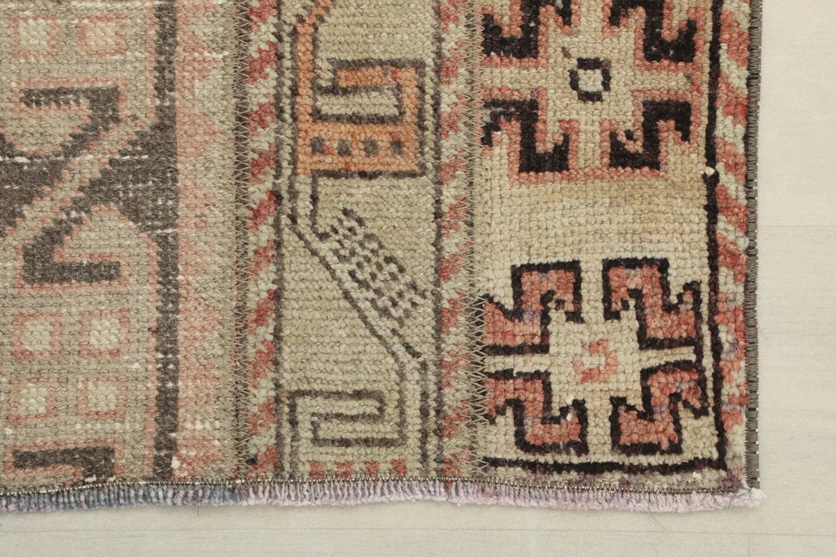 Corner detail showing the short, natural fringe and the woven structure of the rug's end.