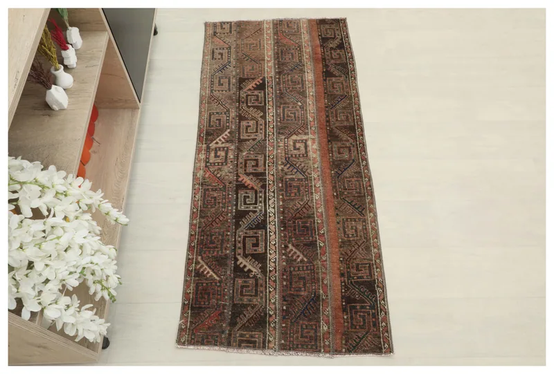 Full top view of the brown and rust tribal geometric area rug on a white background.