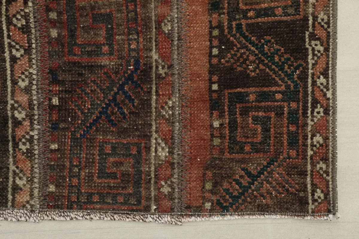 Detailed view of the rug's edge, showcasing the intricate patterns and color variations.