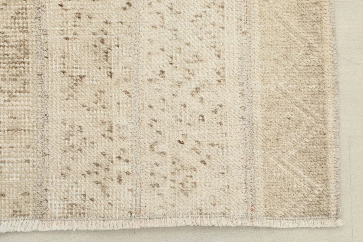 Detailed view of one end of the runner rug, showing the fringe and distressed pile.