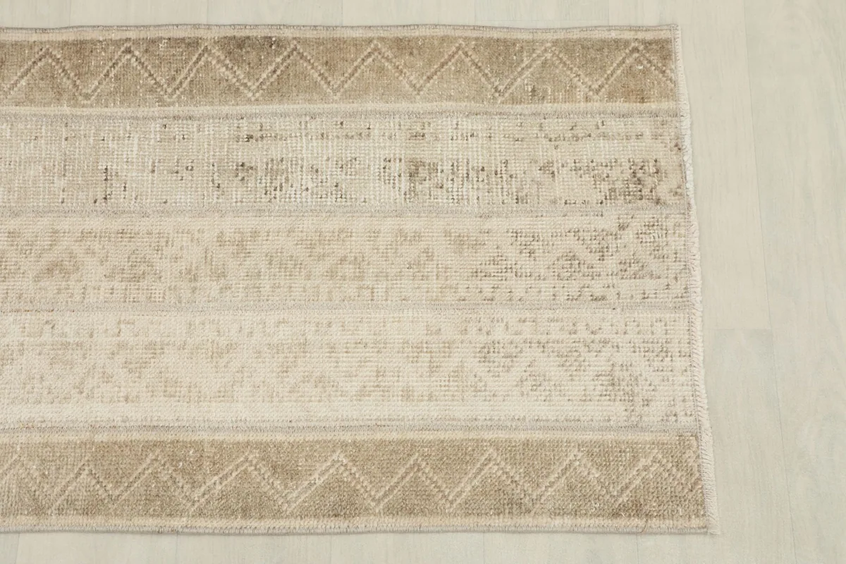 Overhead view of the rug's end, showing the patterned border and field design.