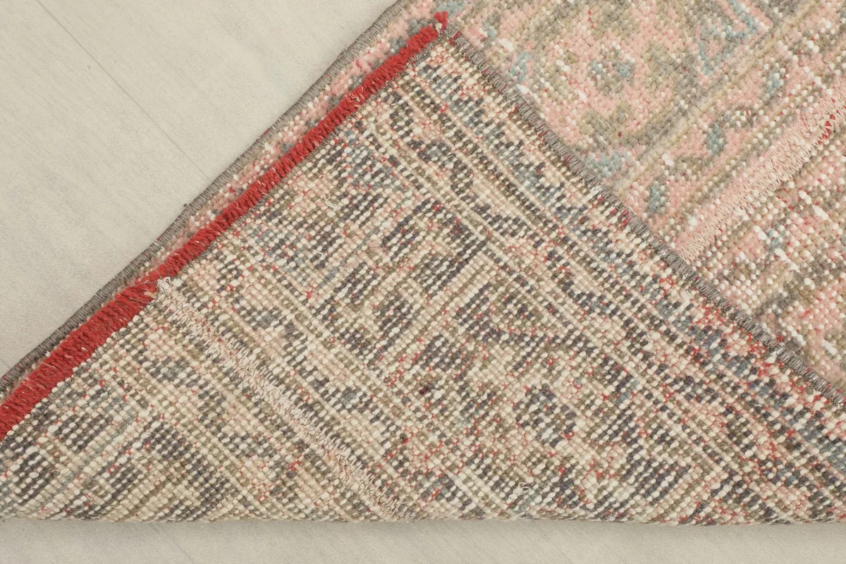View of the back of the rug, showing the hand-knotted cotton foundation and the reverse of the pattern.