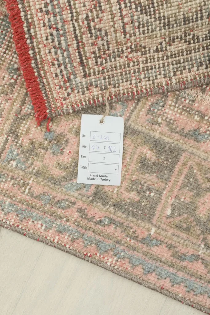 Close-up of the rug's label, confirming its origin and material, alongside the detailed pile.