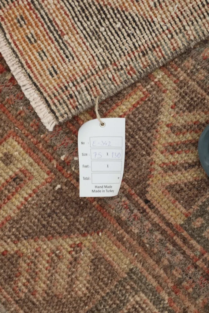 Close-up of the rug's tag, confirming its hand-made origin and dimensions