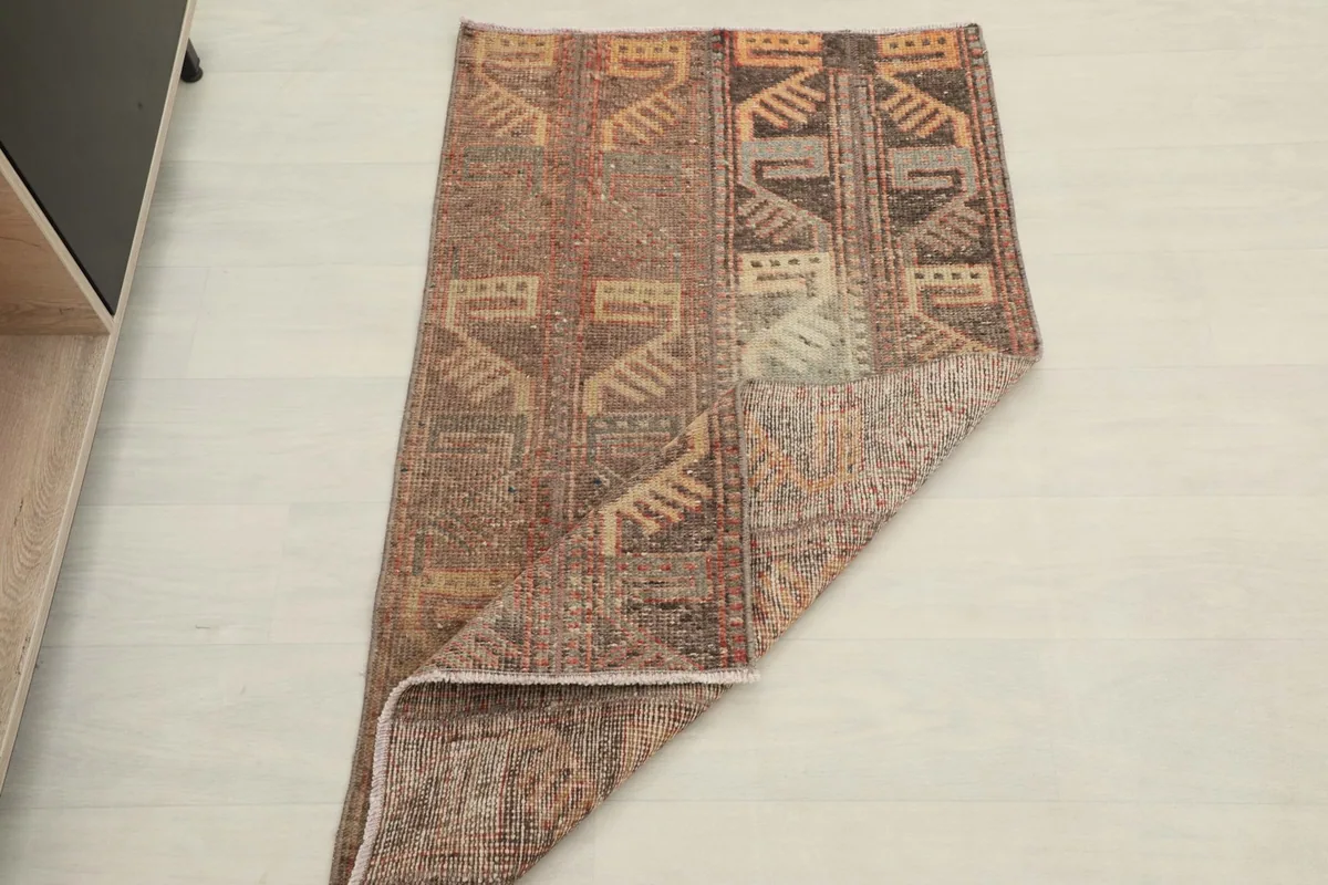 Rug partially folded, illustrating its flexibility and showing both top and bottom surfaces