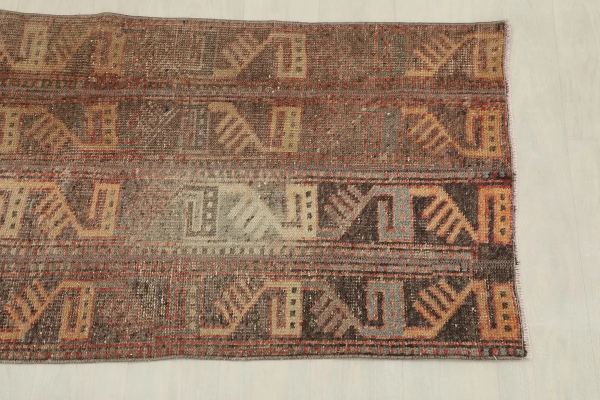 Overhead view of one end of the vintage rug, displaying the repeating tribal patterns