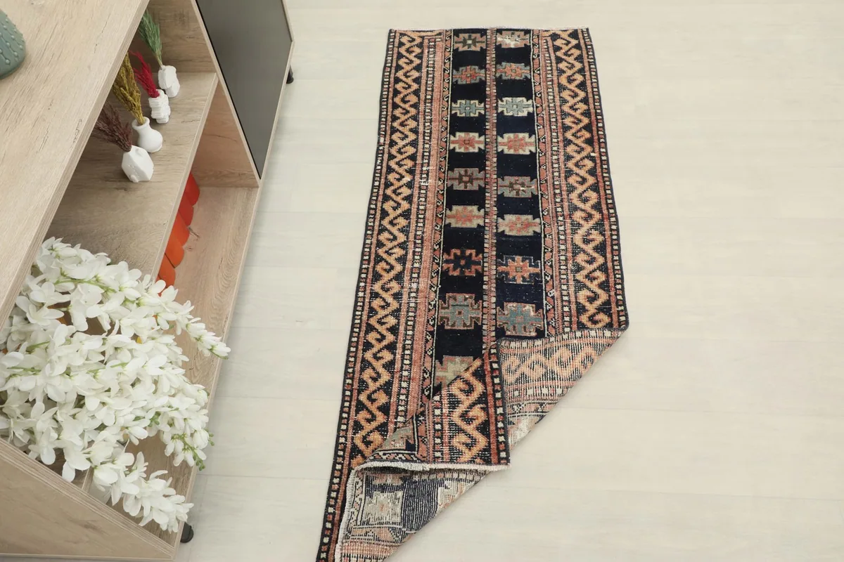 Angled view of the runner rug with one end folded back, showing the back and front textures.