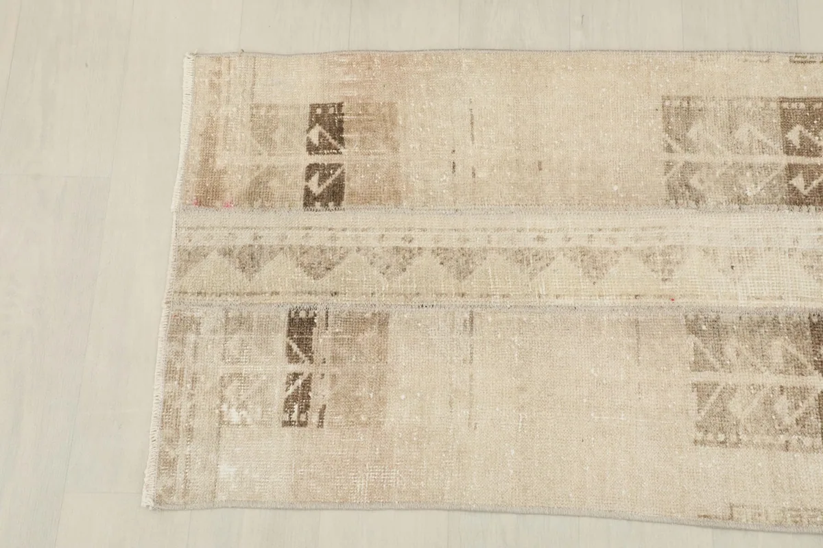 Angled view of the lower half of the rug, showing the faded geometric patterns.