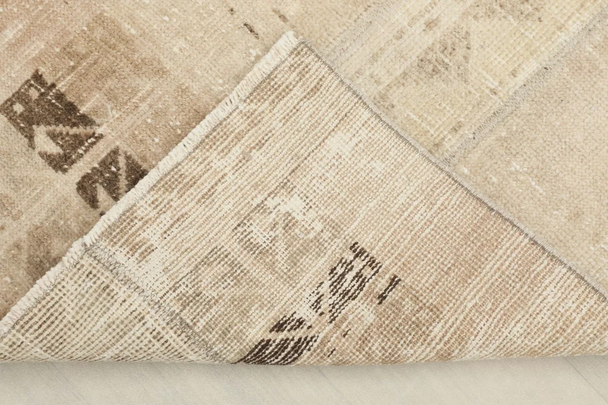 View of the rug's underside, revealing the hand-knotted cotton foundation and wool pile.