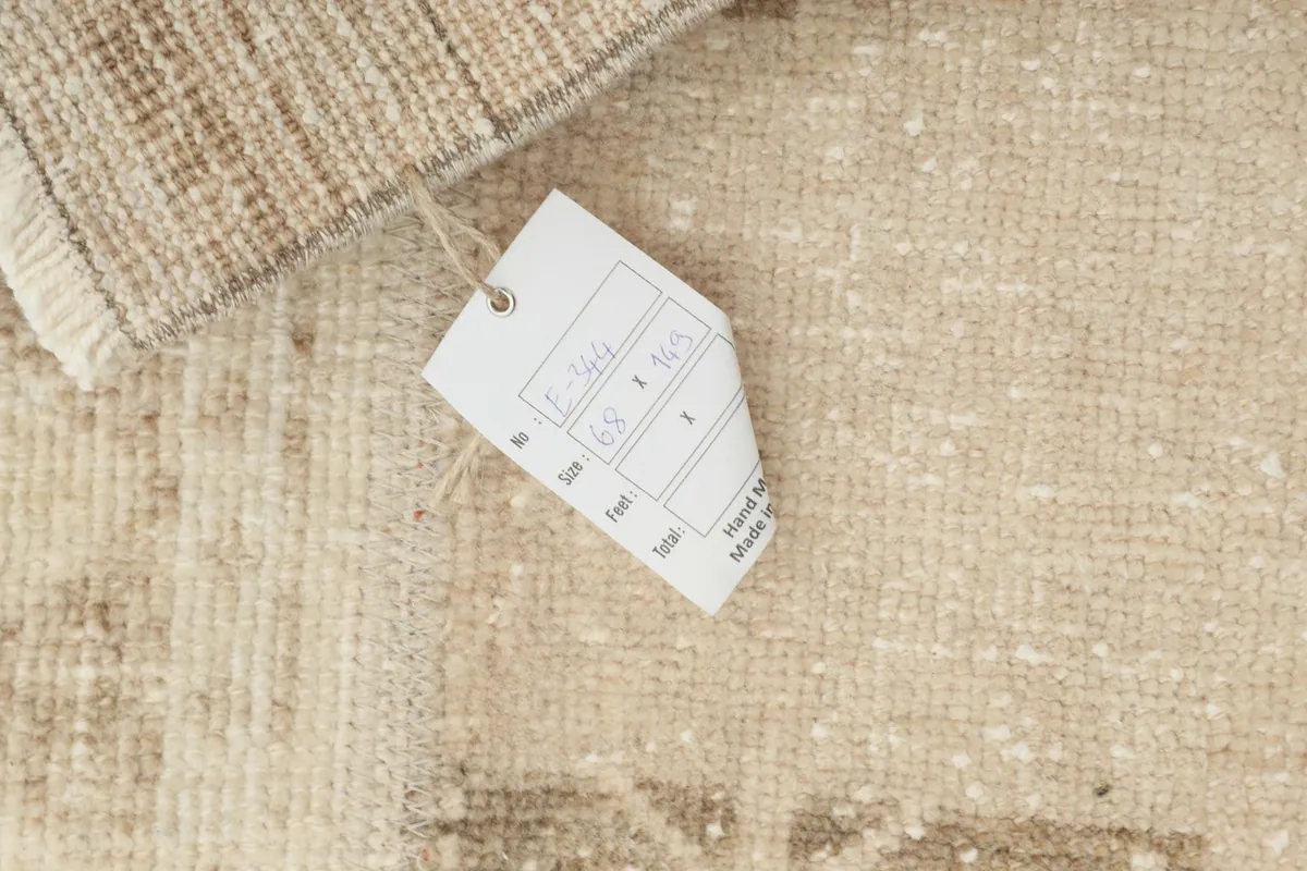 Close-up of the product tag attached to the rug, showing size and material details.
