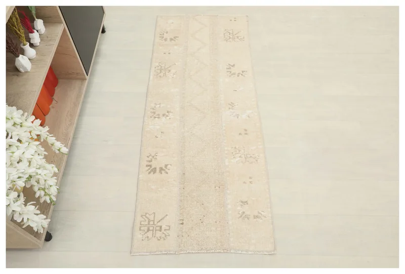 Full top view of the 1'11" x 4'10" beige vintage Anatolian runner rug on a light floor.