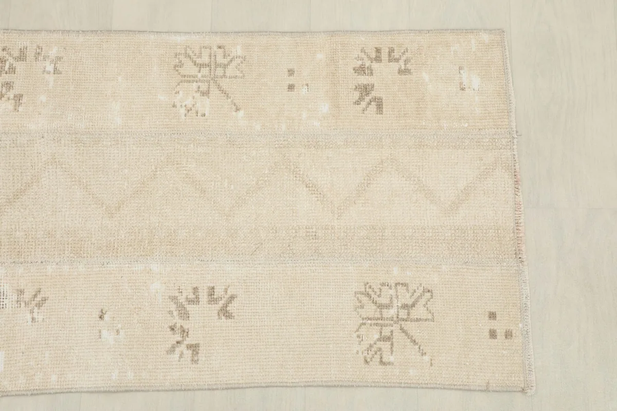 Overhead detail of the rug's pattern, including a central zigzag stripe and scattered motifs.