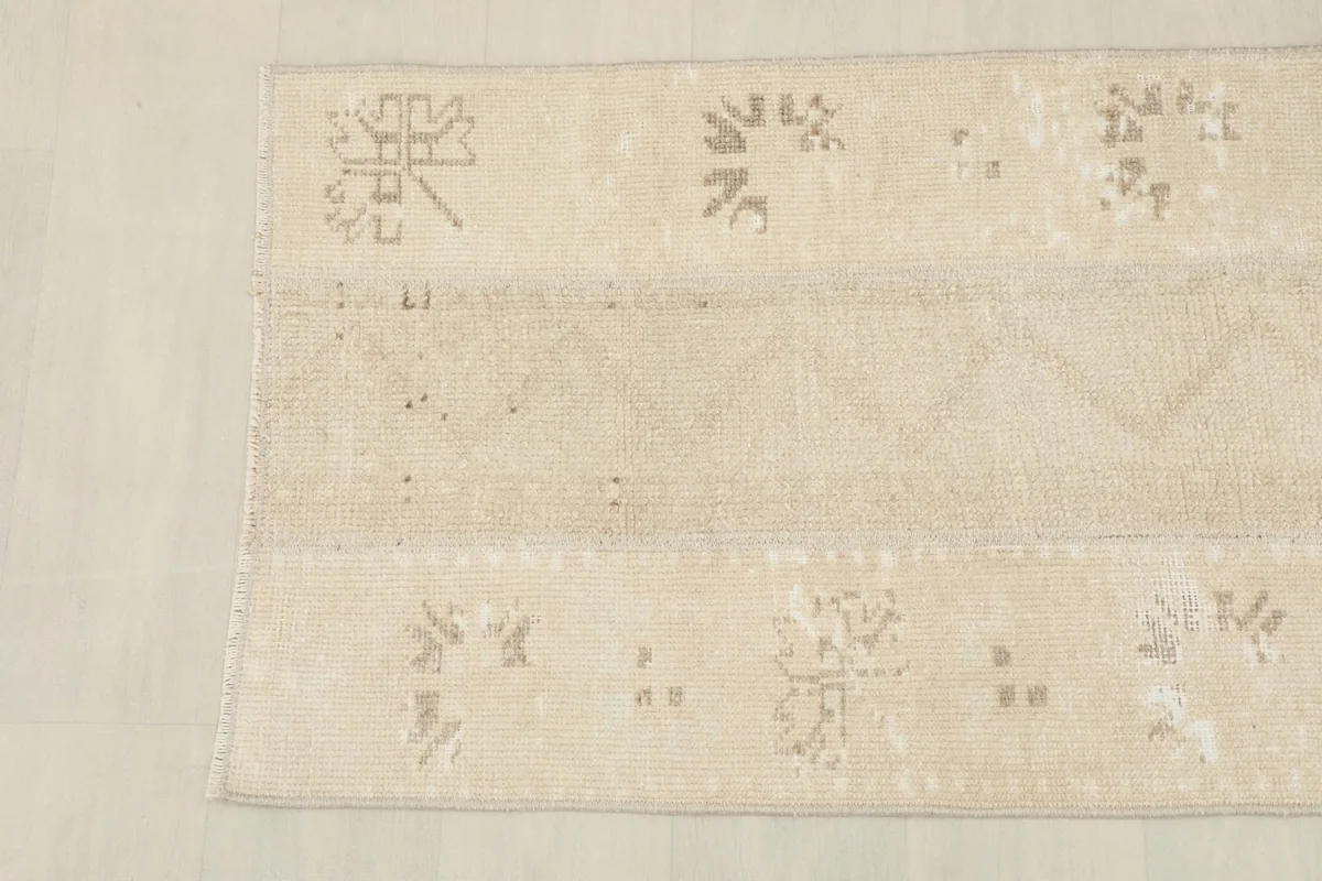 Close-up of the rug's pattern and texture, showing areas of wear and color variation.