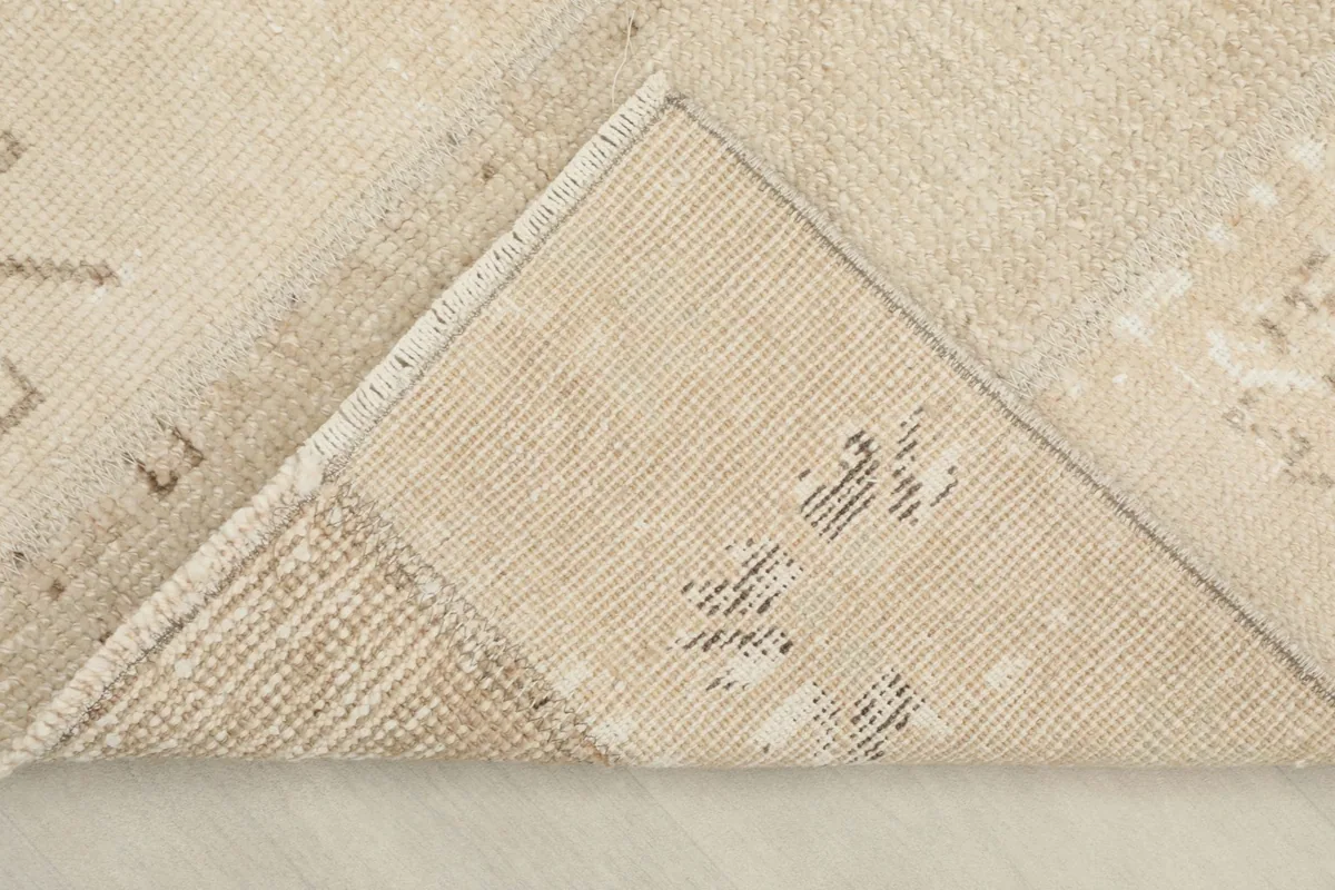 View of the rug's underside, revealing the hand-knotted cotton foundation and wool pile.