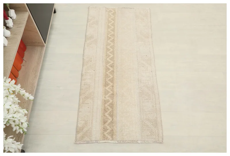 Full top view of the beige and tan vintage Anatolian runner on a white background.