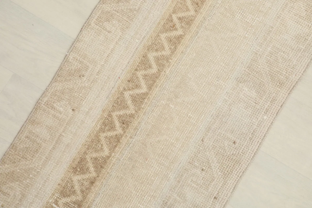 Close-up detail of the central tan geometric zigzag pattern and surrounding beige field.