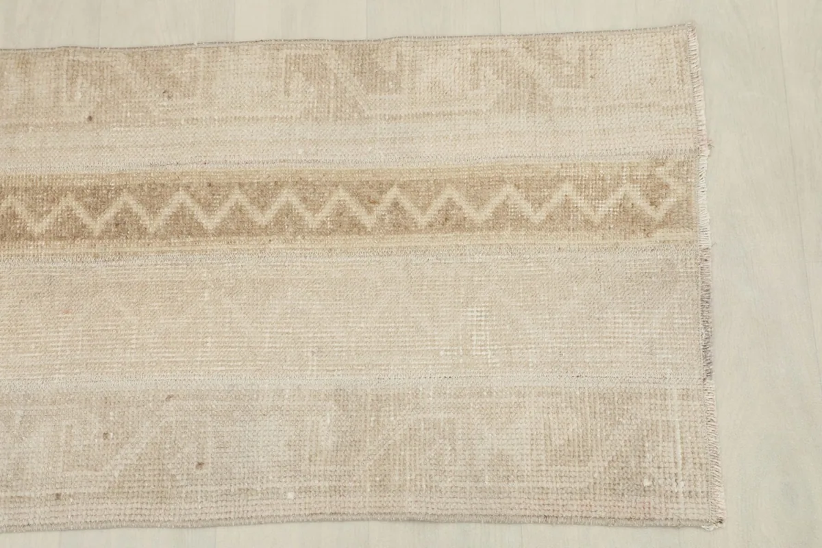 Detailed view of one end of the rug, highlighting the geometric patterns and color variations.
