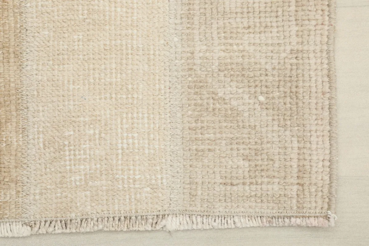 Detail of the short, natural fringe and the finished edge of the hand-knotted rug.