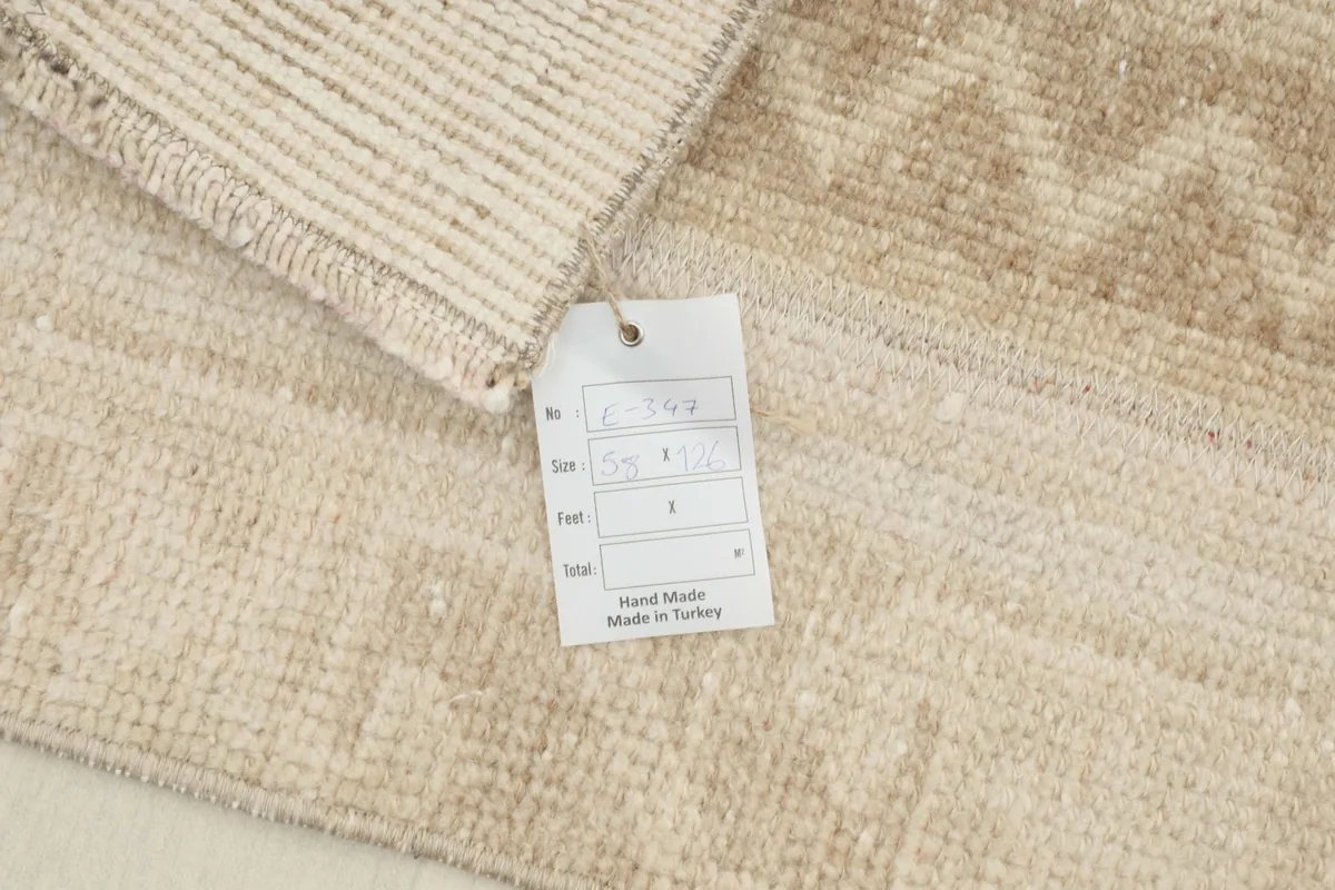 Close-up of the rug's tag, indicating it is hand-knotted and made in Turkey.