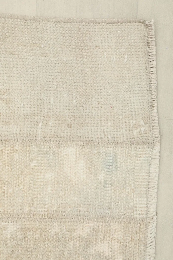 Detail of the rug's edge, showing the tightly woven finish and subtle color variation.