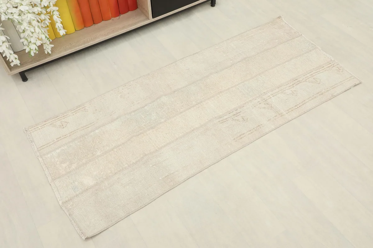 Overhead view of the beige vintage runner showcasing its elongated shape and subtle patterns.