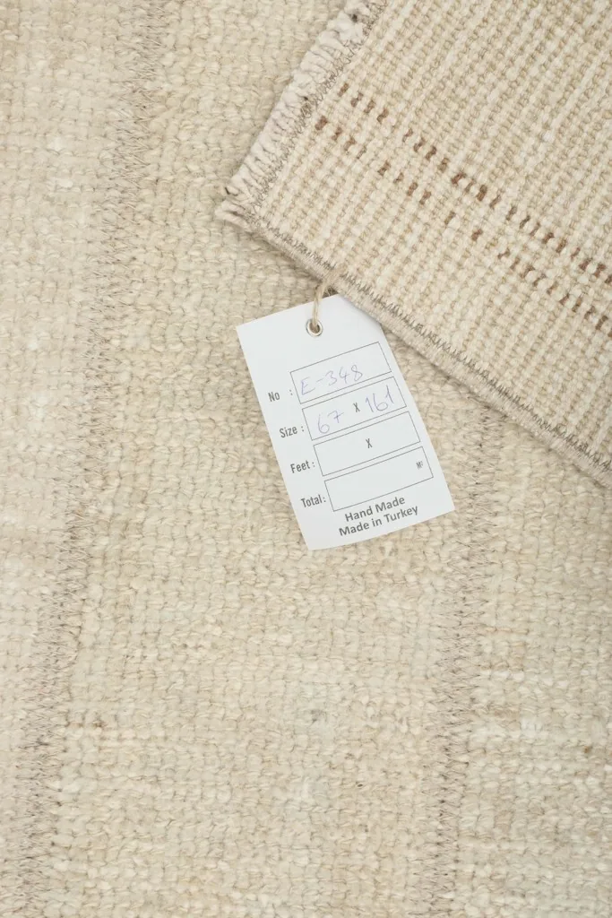 Close-up of the rug's back with a product tag, indicating its handmade origin from Turkey.