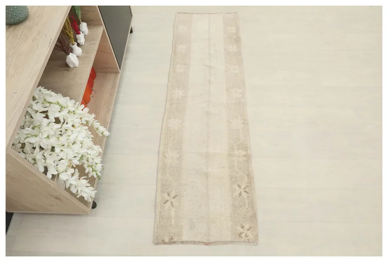 Full top view of the beige and tan striped geometric runner on a light floor.