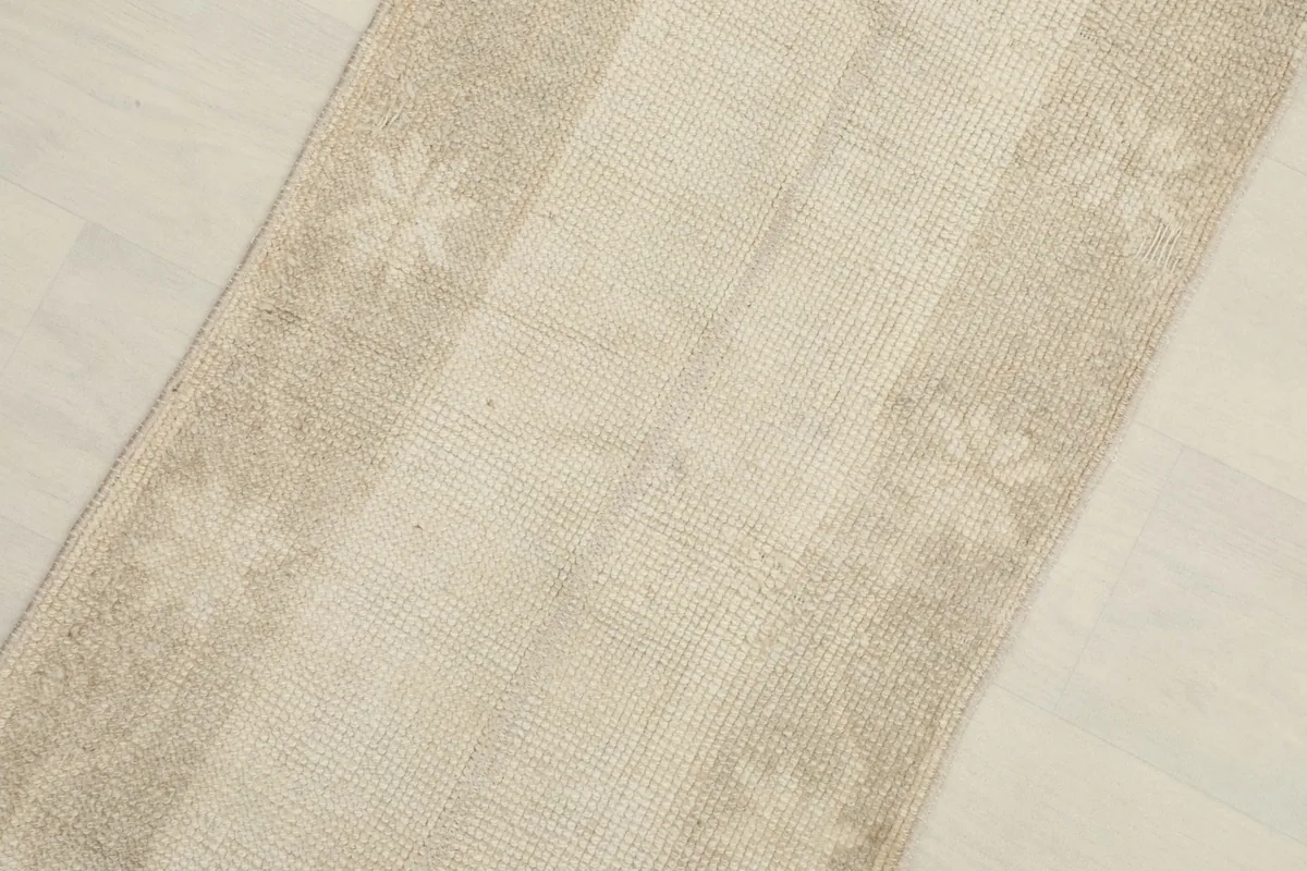 Close-up view of the runner's low pile and geometric motifs in beige and tan.