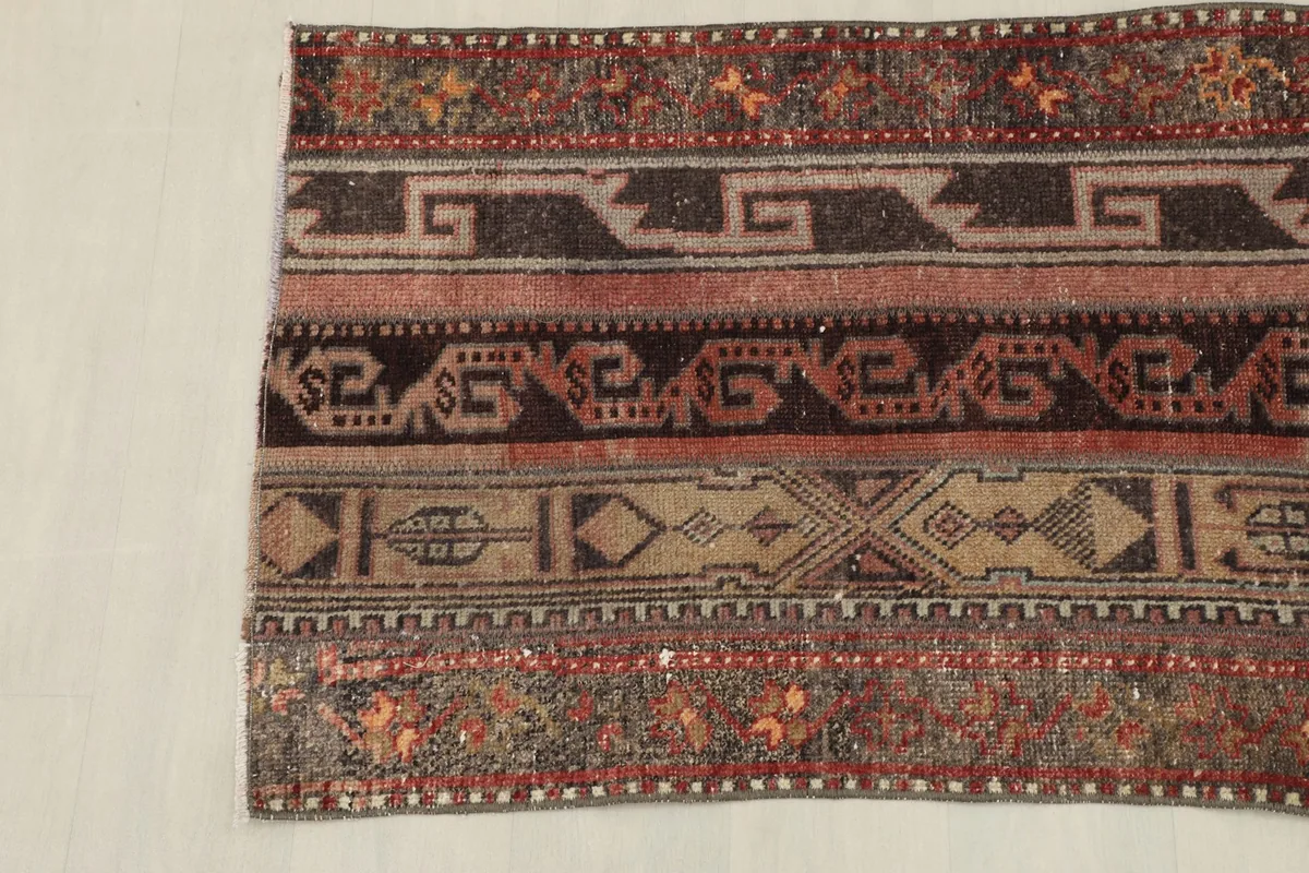 Angled view of the rug's lower section, emphasizing the varied geometric designs