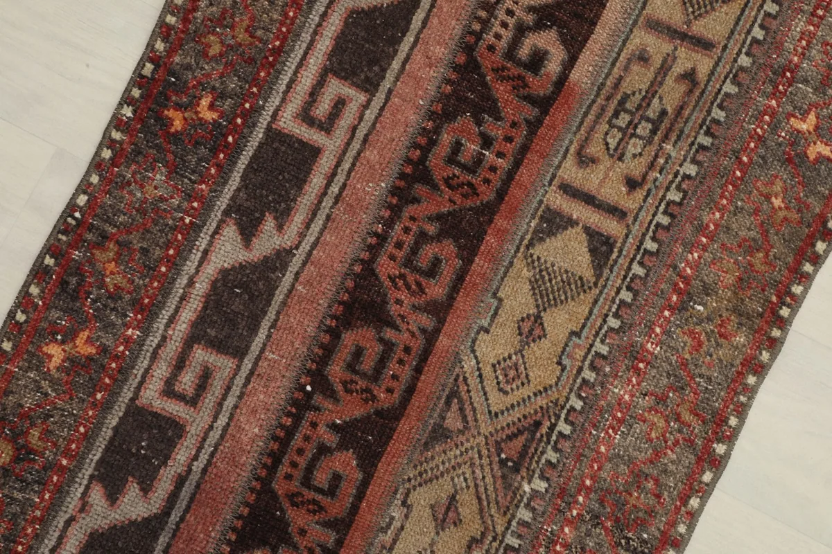 Close-up of the central brown and rust striped geometric patterns on the rug