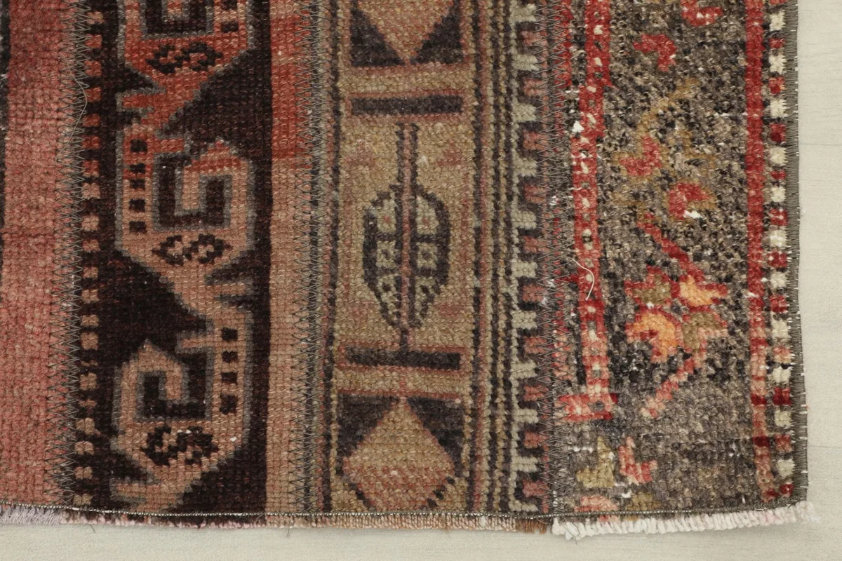 Close-up of the rug's end, highlighting the various stripe designs and natural wear