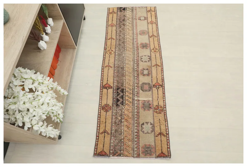 Full overhead view of the beige geometric tribal runner on a white background