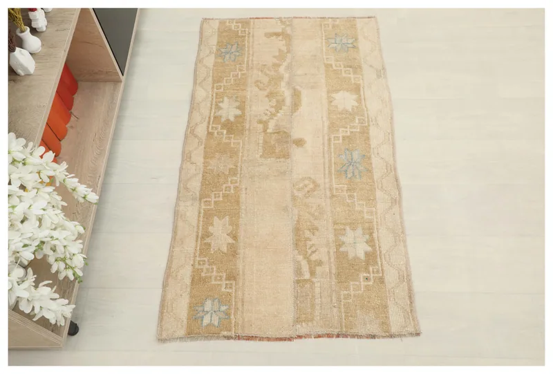Full top view of the beige and gold vintage Anatolian area rug on a white background.