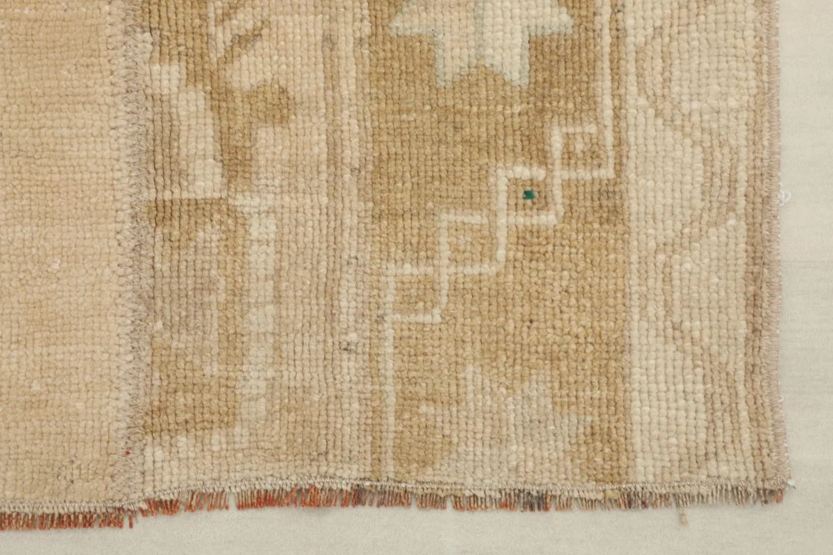 Close-up of the rug's edge, showing the hand-knotted wool pile and subtle color variations.