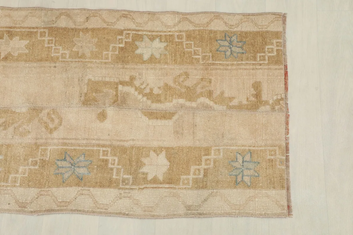 View of the top edge and border design, featuring geometric patterns in beige and gold.