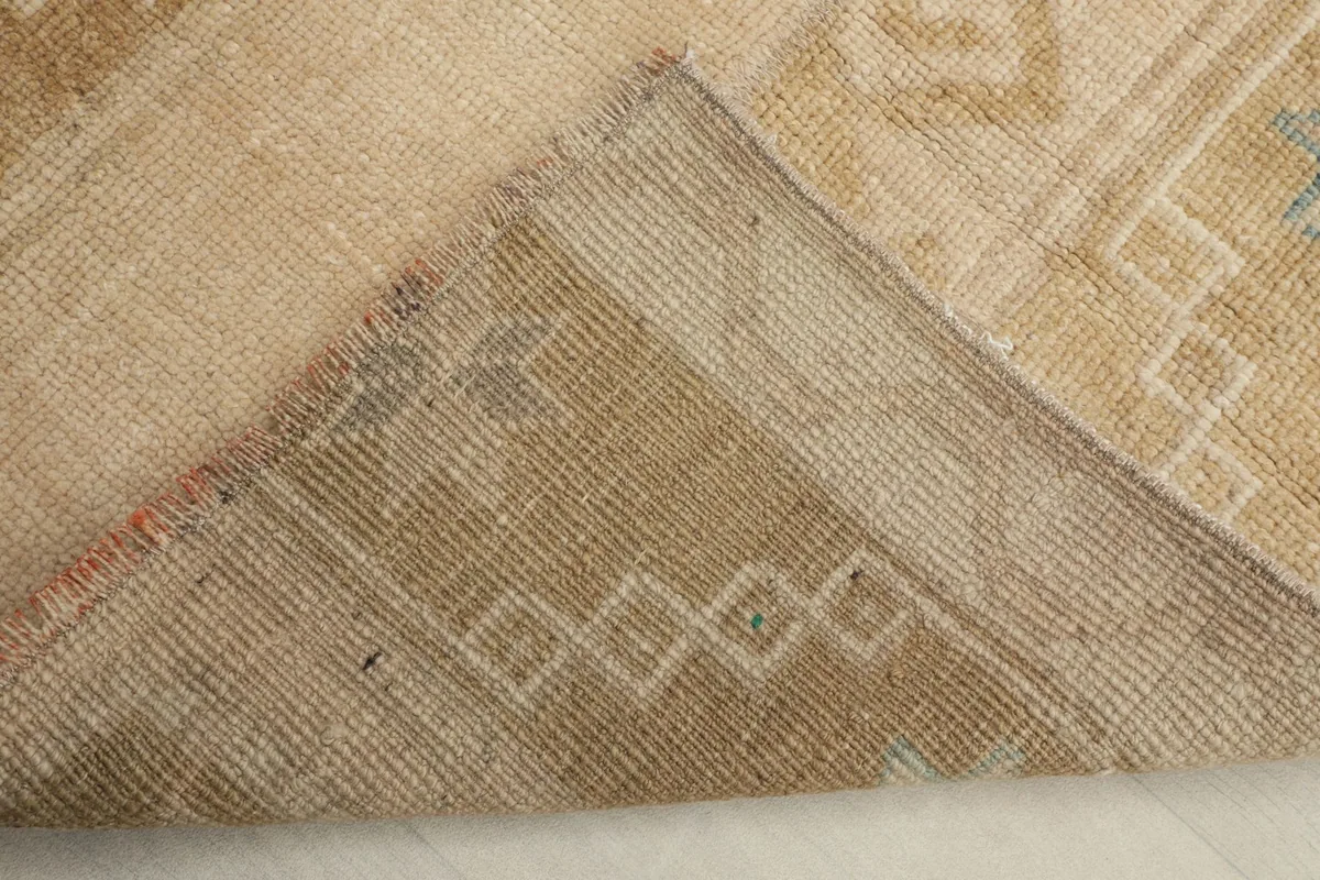 View of the back of the hand-knotted rug, revealing its cotton foundation and knotting.