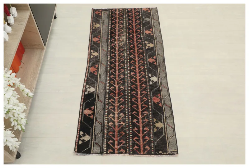 Full overhead view of the black and rust geometric vintage runner on a white background