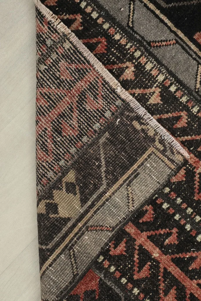 View of the back of the hand-knotted wool rug, showing its cotton foundation