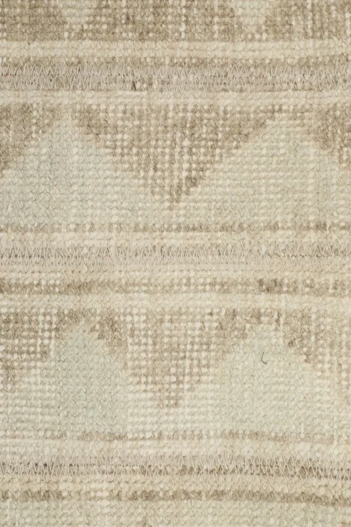 Detailed close-up of the hand-knotted wool pile and the intricate tribal geometric design.