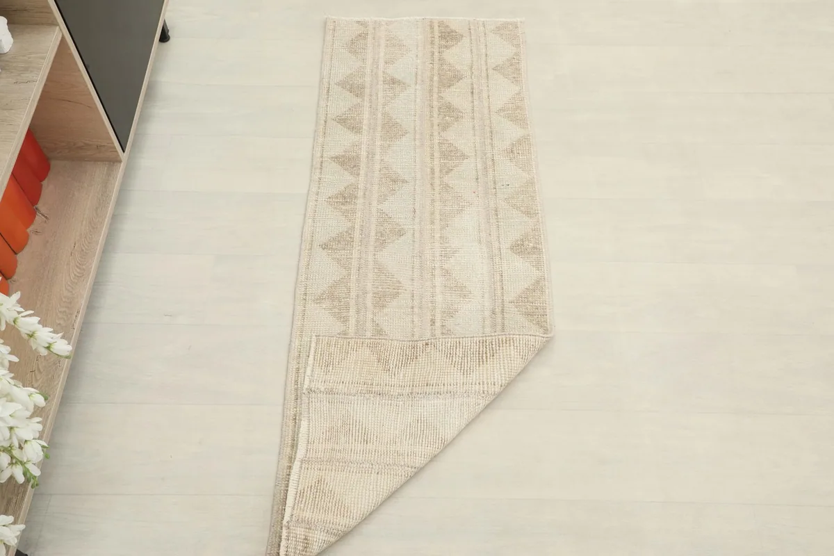 The runner rug folded to show its flexibility and thickness, laid on a light floor.