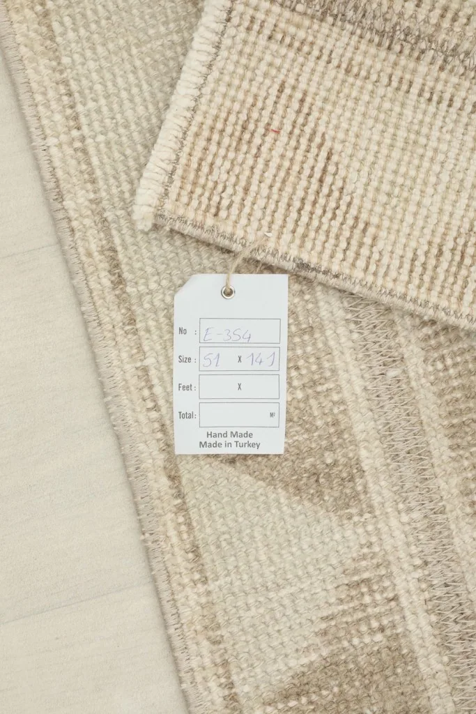 Close-up of the product tag indicating the rug's dimensions and origin, placed on the rug's surface.