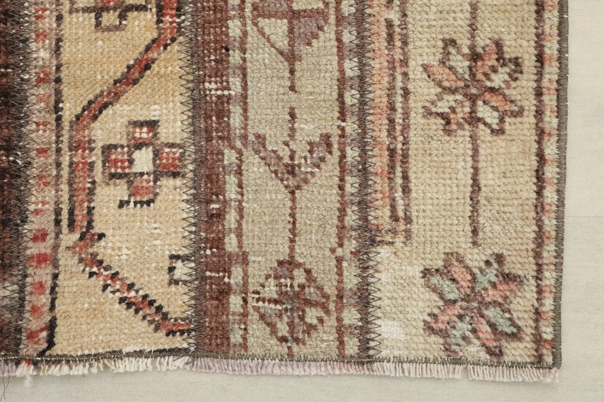 Close-up of the rug's corner, revealing the fringed edge and subtle color variations.
