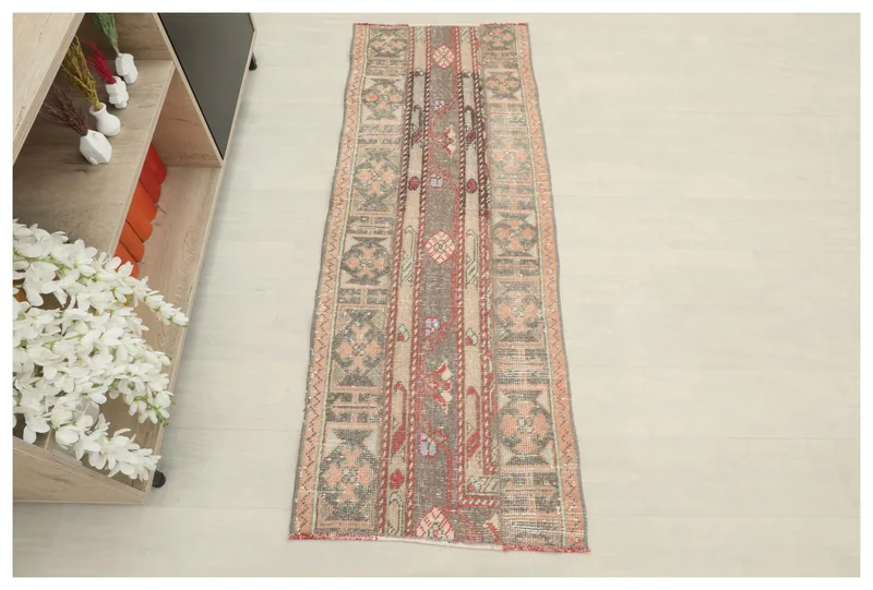 Full overhead view of the gray and beige tribal runner rug on a white floor